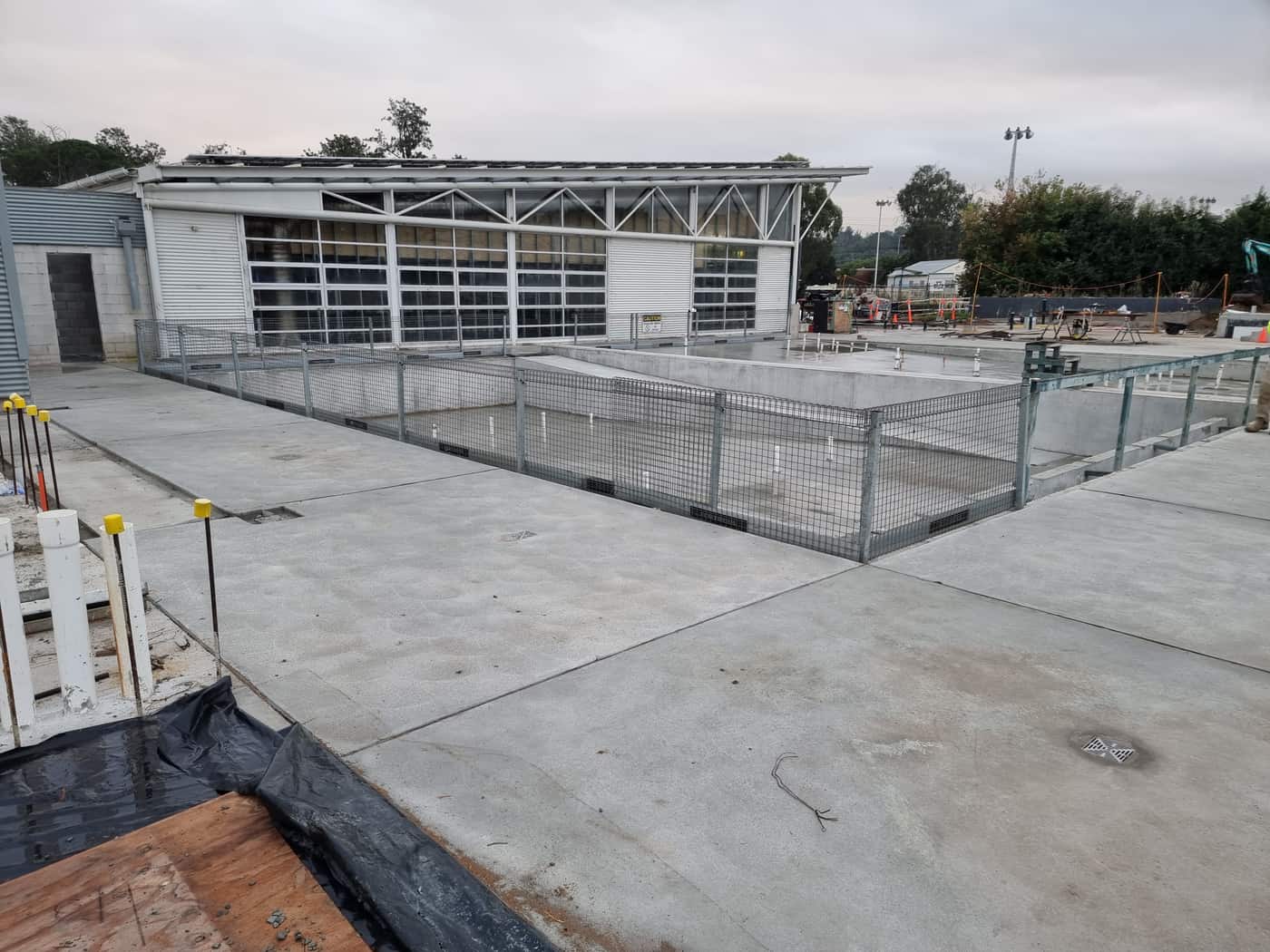 Two new pool shells poured and stripped beside the aquatic centre, with the surrounding slab finished around them
